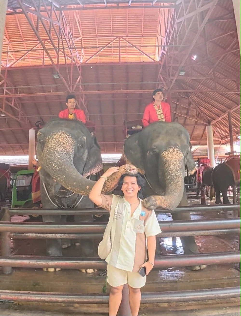Jaja Cortez smiling in front of two elephants